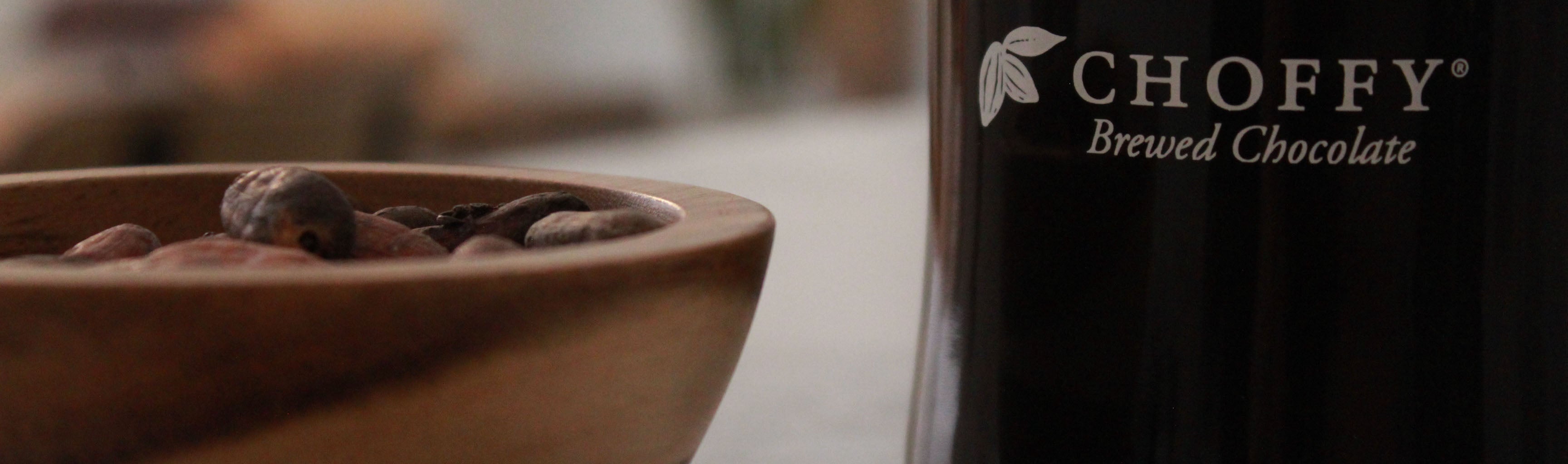 Choffy mug with cacao beans next to it